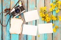 Retro camera and empty old instant paper photo album on wood table with flowers border design Royalty Free Stock Photo