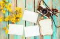 Retro camera and empty old instant paper photo album on wood table with flowers border design Royalty Free Stock Photo