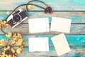 Retro camera and empty old instant paper photo album on wood table with flowers border design Royalty Free Stock Photo