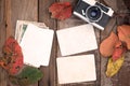 Retro camera and empty old instant paper photo album on wood table with maple leaves in autumn border design Royalty Free Stock Photo