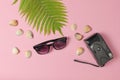 Retro camera, fern leaf, seashells, sunglasses on pink pastel background. The concept of travel, tourism, beach resort. Top View. Royalty Free Stock Photo