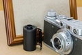 Retro camera, film roll and empty wooden photo frame in vintage