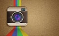 Retro camera icon with rainbow colors on corkboard