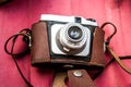 Retro Camera in Leather Case on Red Background