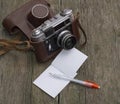 Retro the camera in a leather shabby cover and a notebook Royalty Free Stock Photo