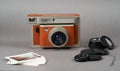 Retro camera and old photo film rolls on gray background Royalty Free Stock Photo