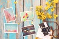 Retro camera and paper photo album on wood table with flowers border design