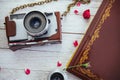 Retro camera roll photo film and flowers on white wooden background Royalty Free Stock Photo