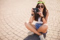 Retro camera shoots girl in the streets of the city. Royalty Free Stock Photo