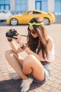 Retro camera shoots girl in the streets of the city. Royalty Free Stock Photo