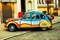 A retro car is parked on an empty street