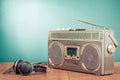 Retro cassette ghetto blaster and headphones on wooden table front mint blue background. Vintage style filtered photo