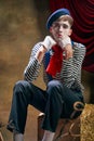 Vintage portrait of male mime artist expressing sadness and loneliness over dark retro circus backstage background Royalty Free Stock Photo