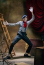 Vintage portrait of male mime artist expressing sadness and loneliness over dark retro circus backstage background Royalty Free Stock Photo