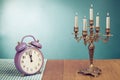 Retro clock and candle holder on table front mint green background Royalty Free Stock Photo