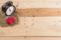 Retro clock with love heart yarn on wood background