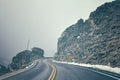 Retro color toned mountain road in fog. Royalty Free Stock Photo