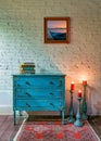 Retro composition of Green vintage cabinet, candlesticks with lighted candles and hanged painting on white bricks wall Royalty Free Stock Photo