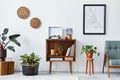 Retro composition of living room interior with mock up poster map, wooden shelf, book, armchair, plant, cacti, vinyl recorder.