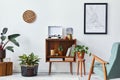 Retro composition of living room interior with mock up poster map, wooden shelf, book, armchair, plant, cacti, vinyl recorder.