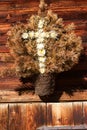 Retro decoration of a alpine hut, made from dry flowers in shape a cross. Outdoors image on a sunny day