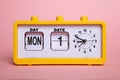 Retro electronic alarm clock and analog flip calendar. Retro design from 60s 70s home interior. Bright yellow color