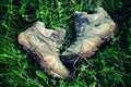 Retro Faded Photo Of Dirty Walking Boots In Green Grass