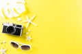 Retro film camera, sunglasses, starfish and sea shell on yellow background for summer holiday and vacation concept Royalty Free Stock Photo