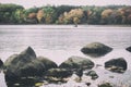 A retro film style photo of a New England lake and forest in the fall