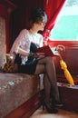 Retro girl reading book in wagon train. Royalty Free Stock Photo