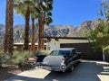 Retro Gray Cadillac with Tail Fin from the 1960s in Front of Mid-Century Modern Home