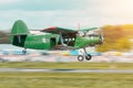 Retro green turbo propeller vintage aircraft flying over the car in the airport Royalty Free Stock Photo