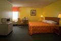 Retro hotel room interior with bed, table and chair. Generative AI