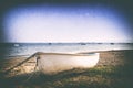 Retro image of a boat on a shingle beach.