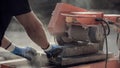 Retro image of building contractor cutting through a paving stone