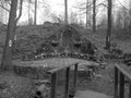Retro image - Rock chapel of Virgin Mary of the Lurds with stone area behind a wooden bridge in the forest Belsky les in Ostrava c