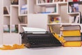 Retro image of writer`s or student`s workplace. Old typewriter and stack of thick books. Royalty Free Stock Photo