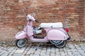 Retro Italian Vespa motorcycle parked near bricks wall