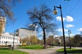 Retro lanterns and benches in the park with green lawns, buildings Music college and apartment, office buildings in the backgrou