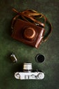 Retro leather case and vintage photo camera on green background, top view, flat lay Royalty Free Stock Photo