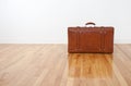 Retro leather suitcase on wooden floor