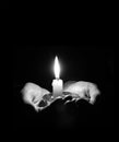 Hands holding a burning candle in dark room Royalty Free Stock Photo