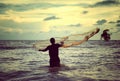 Retro look image of a man throwing fishing net