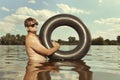 Retro man in summer lake have fun with inner tube