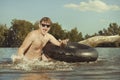 Retro man in summer lake have fun with inner tube Royalty Free Stock Photo