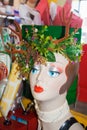 Retro mannequin head with deer and flower headdress and retro toys and packages in background