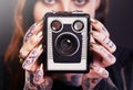 Retro meets alternative. Studio shot of a young tattooed woman holding a vintage camera. Royalty Free Stock Photo