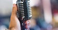 Retro microphone in hand on blurred background Royalty Free Stock Photo