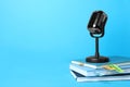 Retro microphone and notebooks on blue background, space for text. Job interview Royalty Free Stock Photo