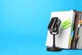 Retro microphone, notebooks and reminder note with words JOB INTERVIEW on light blue background Royalty Free Stock Photo